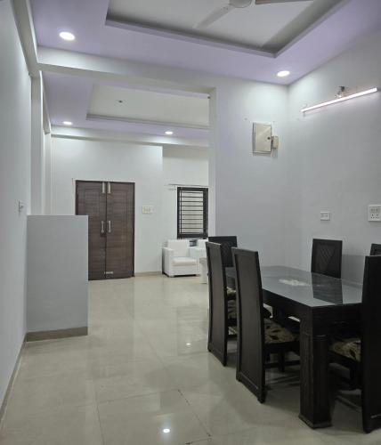 a dining room with a black table and chairs at Satyabhama Home Stay - Opel - Two BHK in Indore