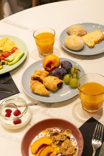 una mesa con platos de comida y vasos de jugo de naranja en Hotel Sport - Terme Krka, en Otočec