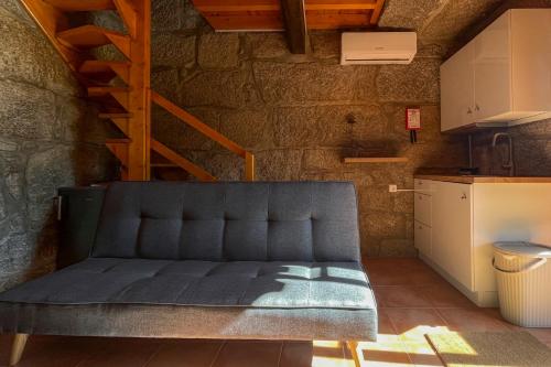 a blue couch in a room with a kitchen at Quinta dos Mascarenhas Nature House in Oliveira do Hospital