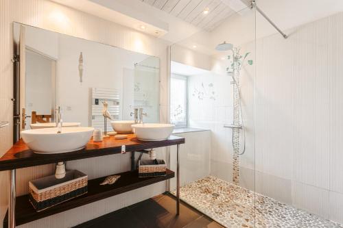 une salle de bain avec deux lavabos et une douche dans l'établissement Maison de la côte, à La Flotte