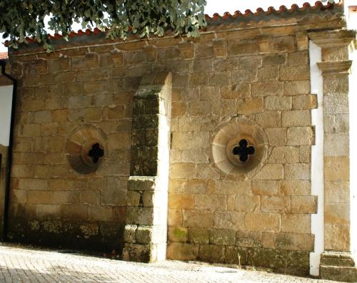 a brick wall with two round windows on it at Quinta dos Mascarenhas Nature House in Oliveira do Hospital