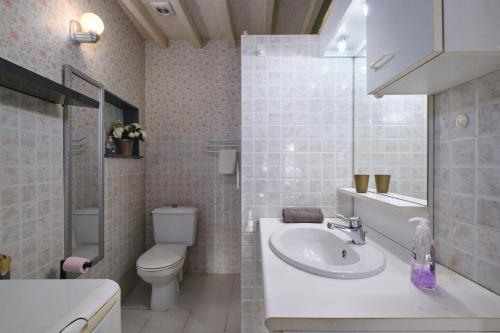 a white bathroom with a toilet and a sink at Maison Irène, Charme et nature pour 2 pers in Véranne