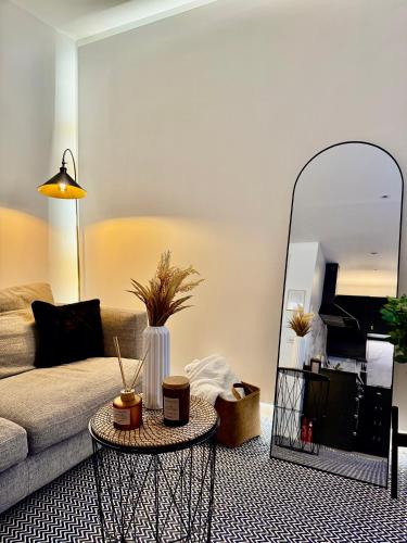 a living room with a couch and a mirror at Superb Duplex in Hendon in The Hyde