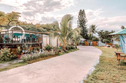 una entrada que conduce a una casa con palmeras en 踏浪星辰Camp, en Dahan