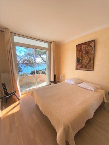 une chambre avec un grand lit et une grande fenêtre dans l'établissement Casa A Spiaggia Pinarello, à Pinarellu