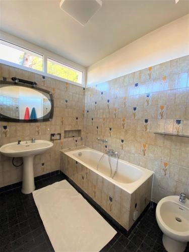 une salle de bain avec une baignoire, un lavabo et des toilettes dans l'établissement Casa A Spiaggia Pinarello, à Pinarellu
