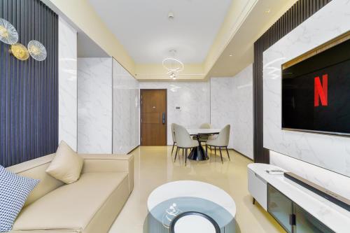 a living room with a couch and a tv at Luxury Condo Ocean View 1,2,3, & 4 Bedrooms Infinity Pool Gym Spa Next to Okada Solaire MOA NAIA Airport in Manila