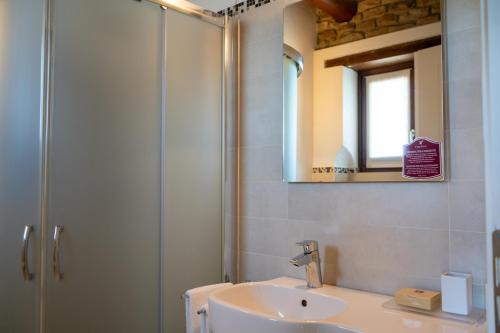 a bathroom with a sink and a shower with a mirror at I Tre Poggi Dimora di Charme in Canelli