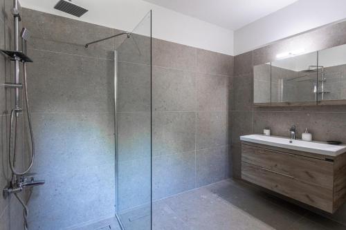 a bathroom with a glass shower and a sink at Elia Villas in Riglia