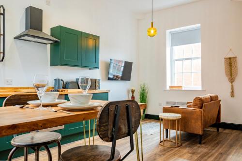 a kitchen with green cabinets and a table and chairs at WhiskAwayStays Foregate Studio no 6 in Worcester