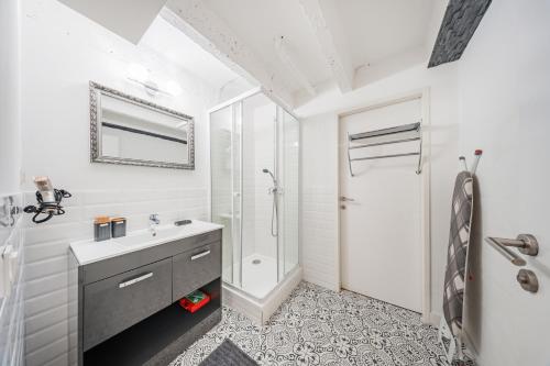 a white bathroom with a sink and a shower at City Center Lofts in Vienna