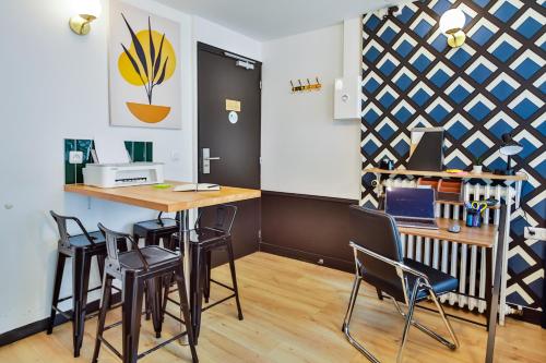 une cuisine avec une table et des chaises dans une pièce dans l'établissement WS Notre-Dame - Linné, à Paris