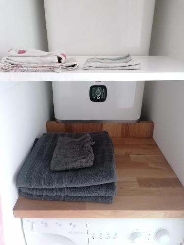 - deux serviettes assises sur une étagère dans une salle de bains dans l'établissement Charmant studio - Terrasse - Parking gratuit, à Montpellier