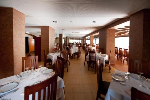 a dining room with tables and chairs with white table cloth at Hotel Restaurante Campiña Del Rey in Villanueva del Rey