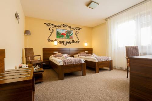 a bedroom with two beds and a window at Grand Hotel Senica, Garni in Senica