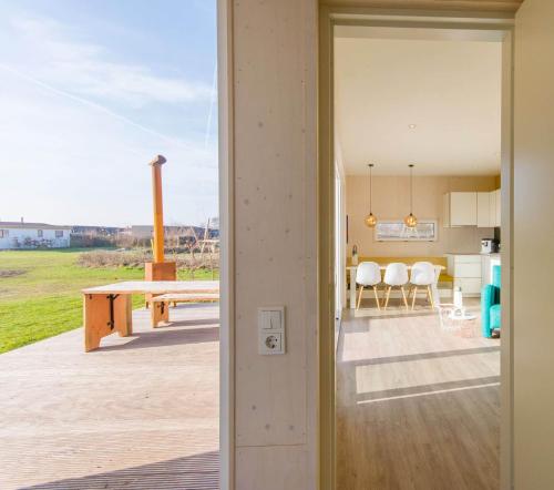 an open door leading to a patio with a table at Cumbuco - Ecohuisjes Terschelling in Midsland