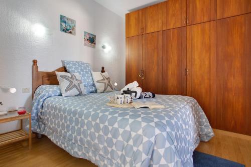 a bedroom with a bed with a blue and white comforter at Los Secretos De San Marcos Seaview in San Marcos