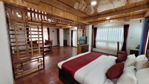 a bedroom with a bed in a room with wooden walls at Rufina Greenland Premiere in Pelling