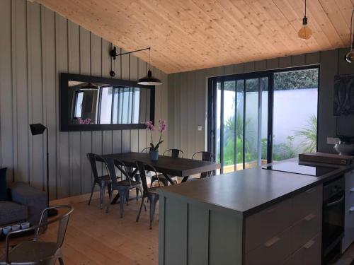 une cuisine et une salle à manger avec une table et des chaises dans l'établissement Les Cabines, à Sainte-Marie de Ré