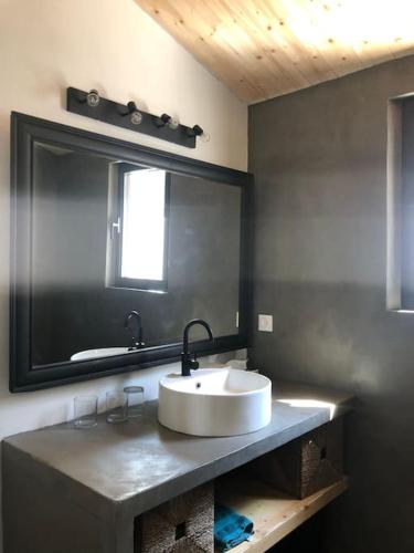 une salle de bain avec un lavabo et un grand miroir dans l'établissement Les Cabines, à Sainte-Marie de Ré