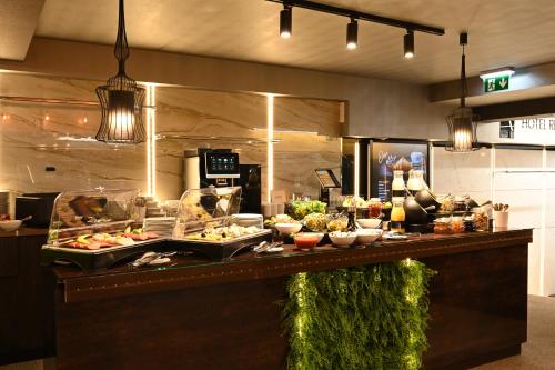 a buffet line with food on display in a restaurant at Fashion City Hotel Superior in Budapest