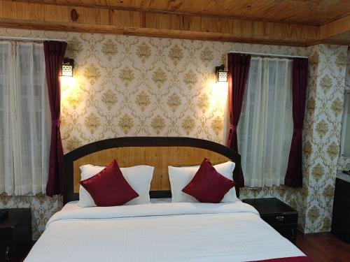 a bedroom with a large bed with red pillows at Rufina Greenland Premiere in Pelling