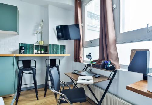 Cette chambre comprend un bureau, des chaises et une table. dans l'établissement WS Jardin du Luxembourg - Boissonade, à Paris