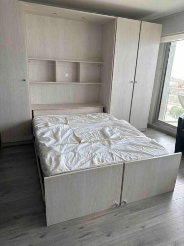 une chambre avec un lit blanc et une fenêtre dans l'établissement Charmant studio face mer - 2 personnes, à Le Touquet-Paris-Plage