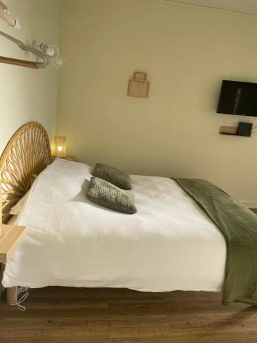 une chambre avec un lit blanc avec deux oreillers dessus dans l'établissement Hypnos-Hébergement champenois, à Châlons-en-Champagne