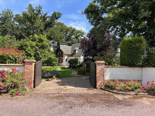 eine Auffahrt, die zu einem Haus mit einem Tor führt in der Unterkunft Charmante Maison de Ferrières in Ferrières-Haut-Clocher