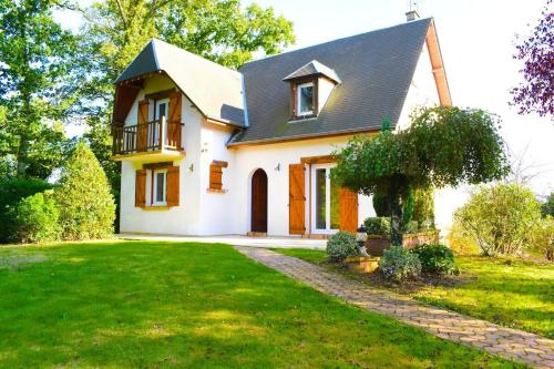 ein Haus mit einem grünen Rasen davor in der Unterkunft Charmante Maison de Ferrières in Ferrières-Haut-Clocher