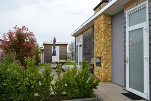 a garden outside a house with a stone wall at Biebosch - Garden house in Valkenburg