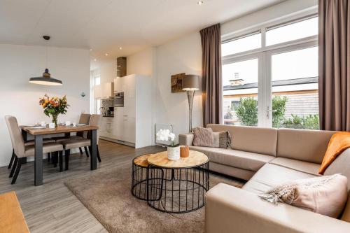 a living room with a couch and a table at Biebosch - Garden house in Valkenburg