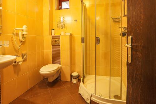 a bathroom with a shower and a toilet and a sink at Grand Hotel Senica, Garni in Senica