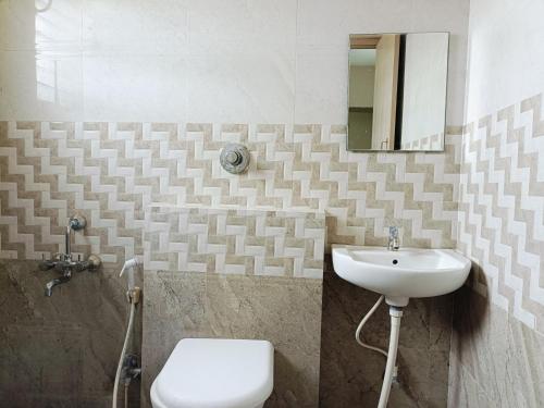 a bathroom with a sink and a toilet at 2BHK Flat by SR Renton Comfort Homestay Mysore @ Vijayanagar 2nd stage Mysore in Mysore