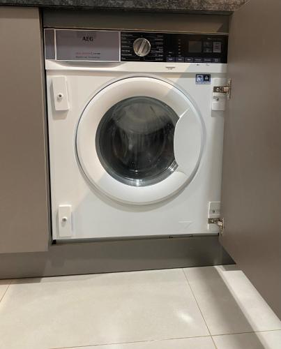 a washing machine in a kitchen with a counter at Beachfront 2BHK apartment at Al Mouj in Seeb