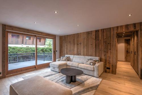un salon avec un canapé et une table dans l'établissement Le Refuge contemporain - Welkeys, à Megève