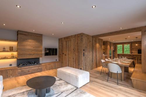 - un salon avec des murs en bois, une table et des chaises dans l'établissement Le Refuge contemporain - Welkeys, à Megève