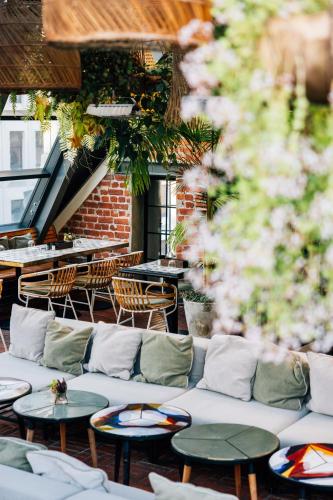 a patio with tables and couches in a restaurant at Gorgeous George by Design Hotels ™ in Cape Town