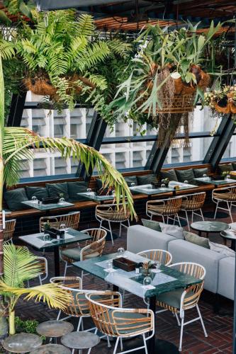 a restaurant with tables and chairs and plants at Gorgeous George by Design Hotels ™ in Cape Town