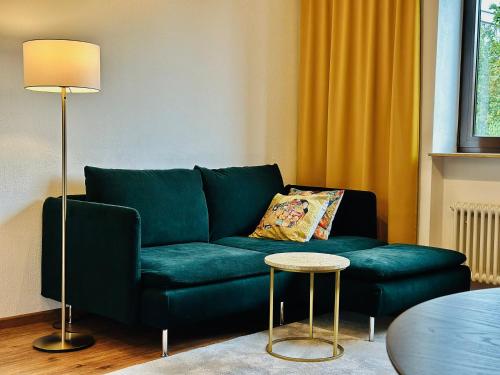 a green couch in a living room with a table at Pfalz Apartments - modern, stylisch und in Toplage! in Neustadt an der Weinstraße