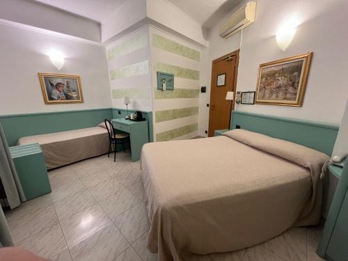 a hotel room with two beds and a desk at Hotel Marina in Sestri Levante