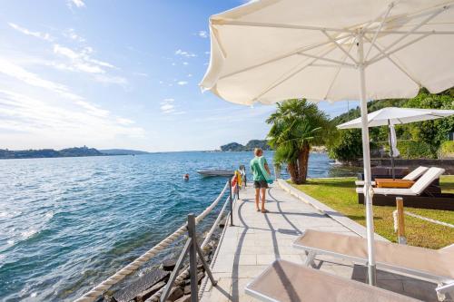 a woman standing on a dock next to a body of water at Resort Antico Verbano in Meina