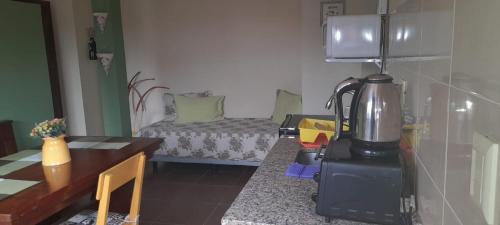 a kitchen with a coffee maker and a table with a bed at ZUHAUSE in Puerto Iguazú
