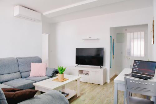 een woonkamer met een bank en een tv bij APARTAMENTO LOS LANCES PLAYA in Tarifa