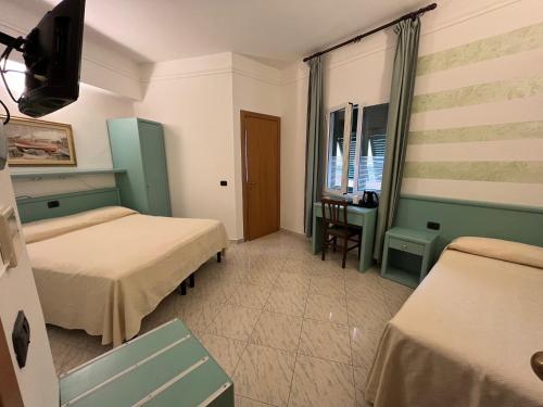 a hotel room with two beds and a desk at Hotel Marina in Sestri Levante