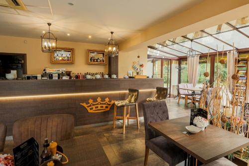 a restaurant with a bar with chairs and tables at Grand Hotel Senica, Garni in Senica