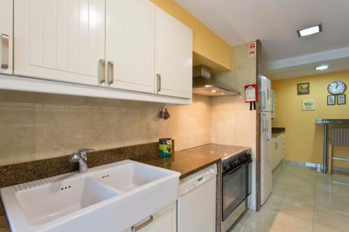 a kitchen with white cabinets and a sink at VIVA Belos Ares in Porto