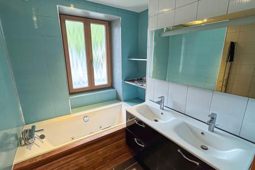 une salle de bain avec un lavabo, une baignoire et un miroir dans l'établissement Montricher Karellis, à 5 min de Saint Jean de Maurienne, à Montricher-Albanne