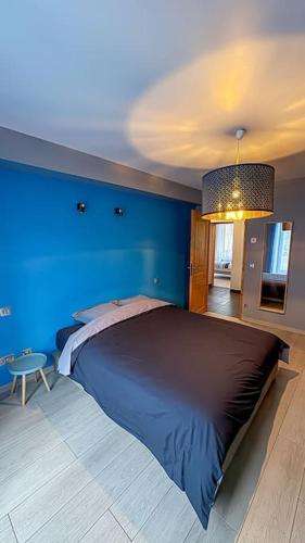 - une chambre bleue avec un lit et un mur bleu dans l'établissement Montricher Karellis, à 5 min de Saint Jean de Maurienne, à Montricher-Albanne